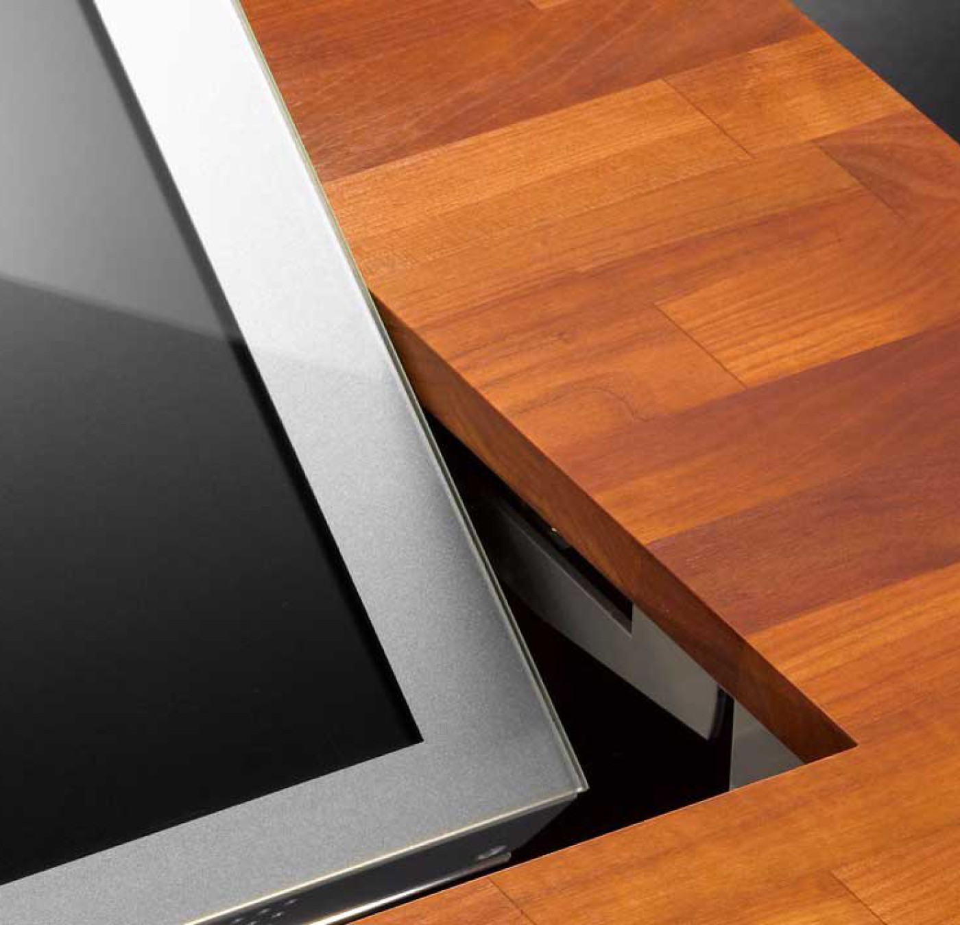 LOFT fold retractable table monitor in a cherry wood table.