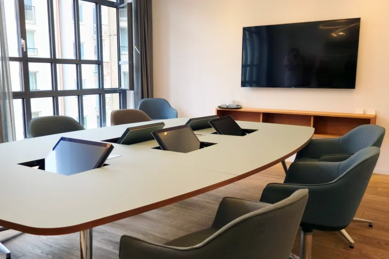 Ein Beurkundungstisch eines Notars in München. Ein tischeinbau Monitor sitzt im Tisch und ermöglicht eine entspannte Mitschau